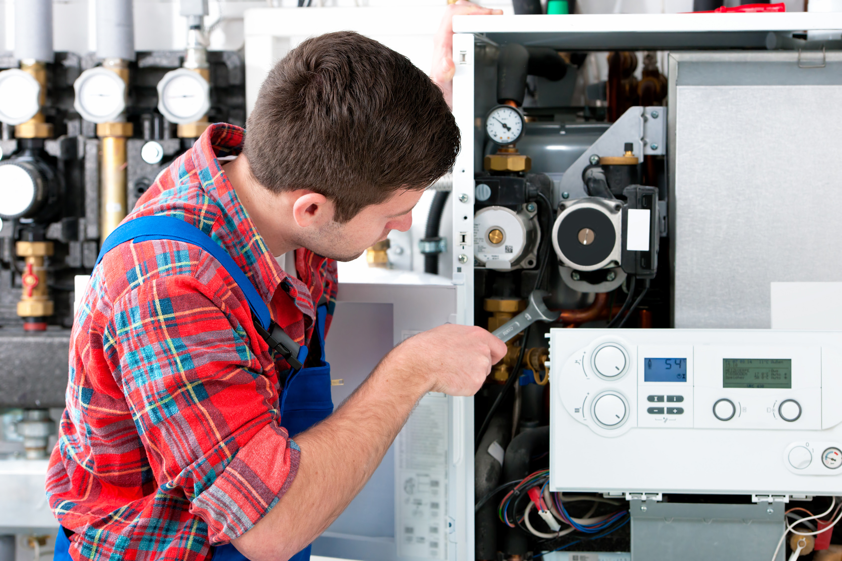 Technician servicing heating boiler Technician servicing the gas boiler for hot water and heating